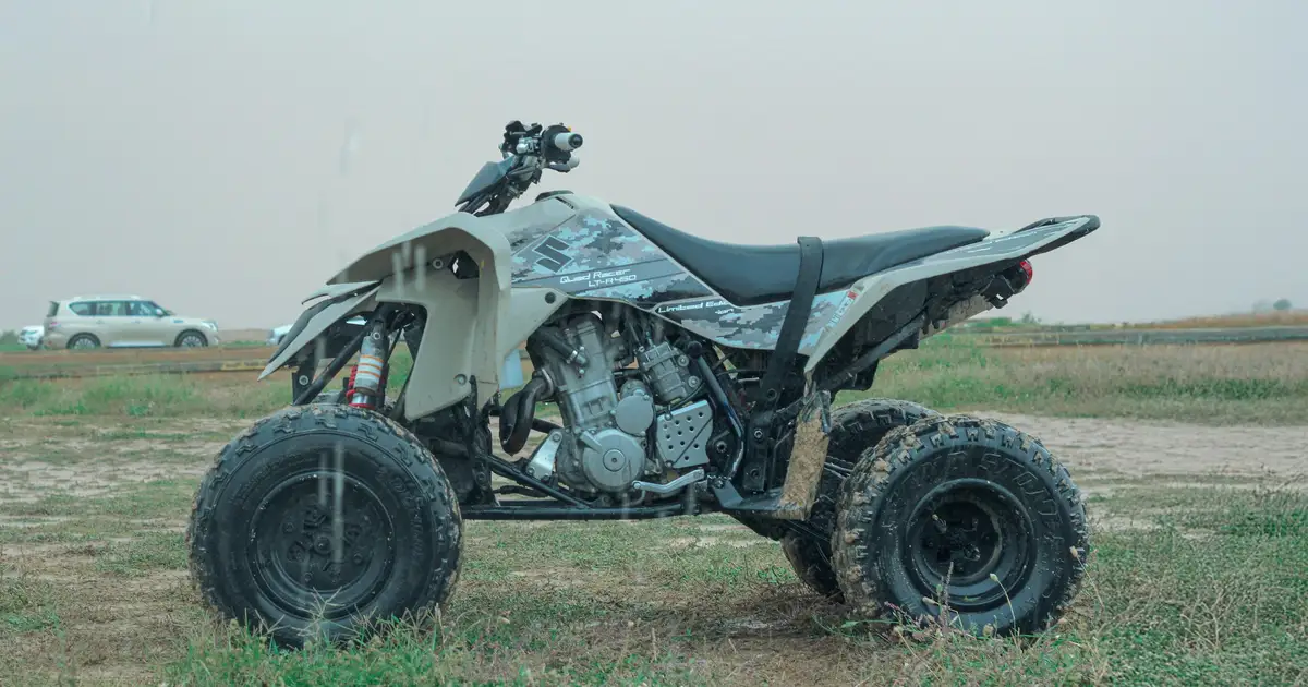 An ATV parked on a dirt trail through a mixed forest in Ontario cottage country on a summer afternoon