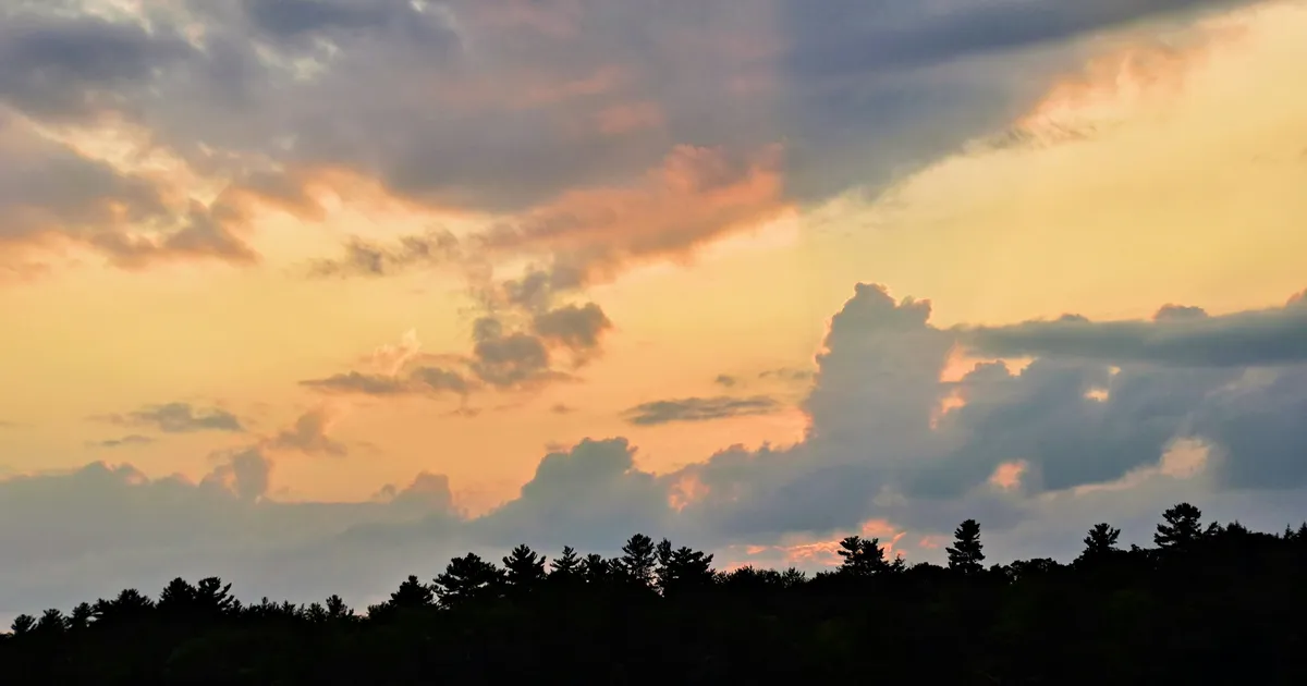 A cottage dock on a calm Kawartha Lakes waterway with a kayak tied alongside in late afternoon light