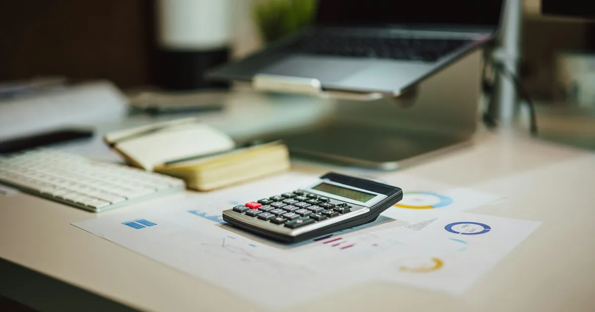 A contractor reviewing blueprints beside a partially framed Ontario cottage rebuild on a lakeside lot